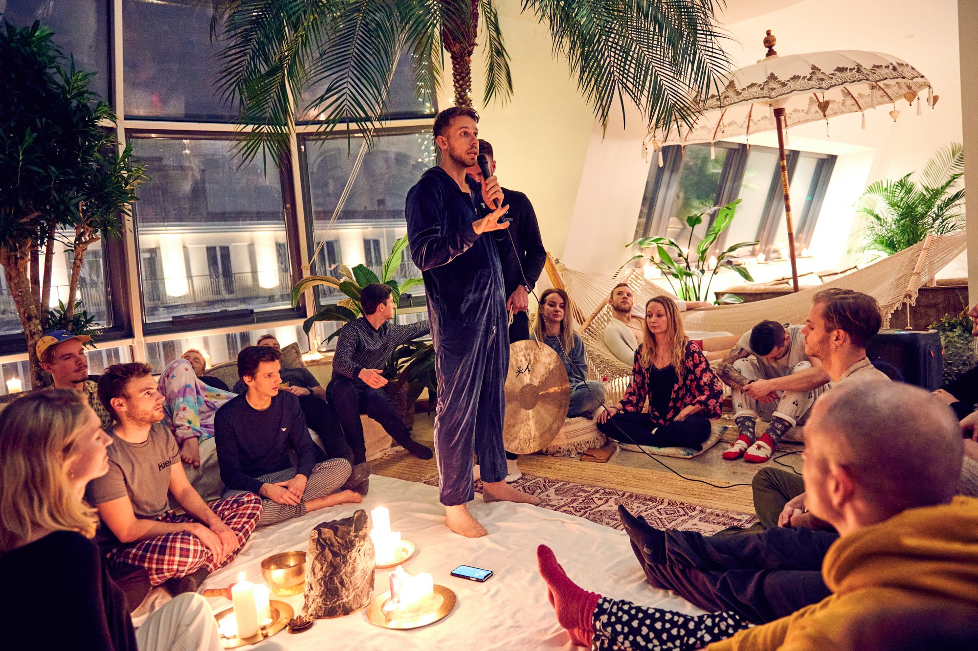 Thomas and guests gathered closely around candles at a Pyjama Party in Berlin.
